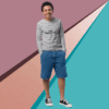 Young man in casual outfit standing against a colorful geometric background.