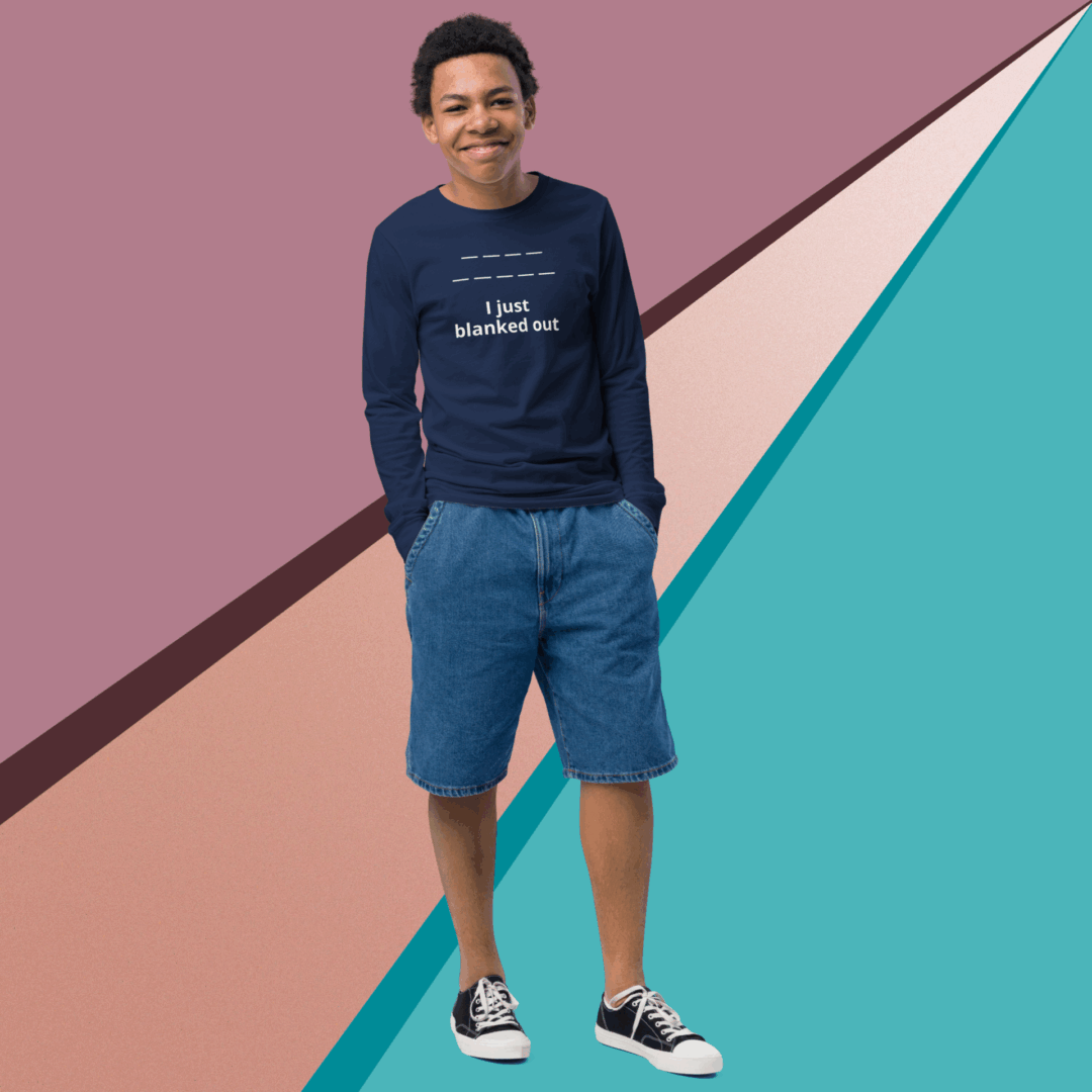 A man in a navy sweatshirt and blue shorts stands against a colorful geometric background.